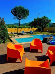 a group of orange chairs sitting next to a swimming pool at Luz&Martins Alojamento in Paredes