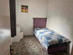 a small bedroom with a bed in a room at Hamre Apartments (Nicholas) in Agios Georgios Pagon
