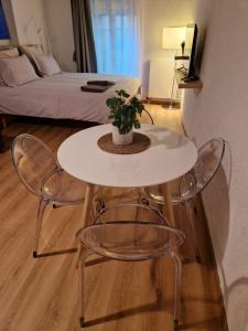 una mesa blanca y sillas con una maceta. en Studio SIEVA, en Lausana
