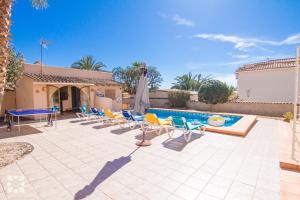 a patio with chairs and a pool with a umbrella at Villa Luna Feliz by Abahana Villas in Calpe