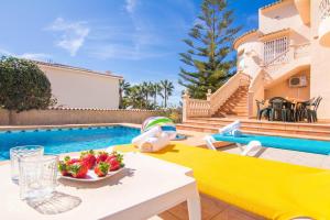 a table with a bowl of fruit next to a pool at Villa Luna Feliz by Abahana Villas in Calpe