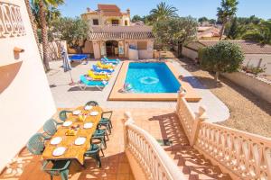 a patio with a table and chairs and a swimming pool at Villa Luna Feliz by Abahana Villas in Calpe