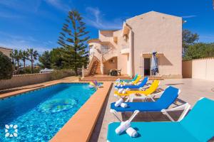 a villa with a swimming pool with blue and yellow chairs at Villa Luna Feliz by Abahana Villas in Calpe