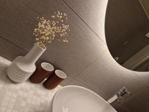 La salle de bains est pourvue de toilettes et d'un vase fleuri. dans l'établissement Studio SIEVA, à Lausanne