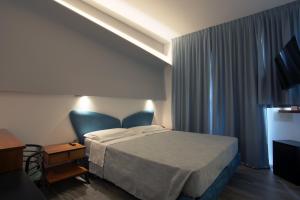 1 dormitorio con cama, escritorio y ventana en Hotel Ali d'Oro, en Rímini