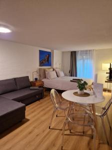 uma sala de estar com uma cama, uma mesa e um sofá em Studio SIEVA em Lausana