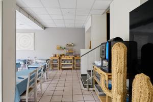 濱海阿熱萊斯的住宿－Hôtel Les Mimosas，一间带桌椅和电视的用餐室