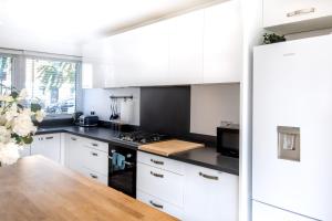 a kitchen with white cabinets and a wooden table at The Camden Retreat in London