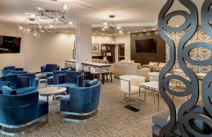 a waiting room with blue chairs and tables at Hilton St. Louis at the Ballpark in Saint Louis