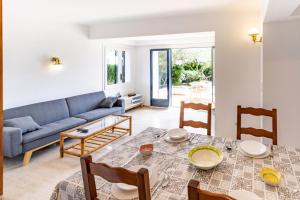 un salon avec une table et un canapé bleu dans l'établissement Cau del Llop 70 - Bonito apartamento con jardín, à Llançà