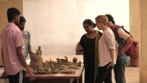 a group of people standing around a table with a sculpture at Clayfingers Art Cottage in Trichūr