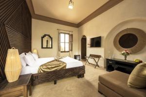 a bedroom with a large bed and a piano at Albakech Boutique Hôtel & Spa in Marrakesh