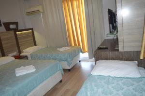 a hotel room with two beds and a mirror at Bülent Kocabaş-Selinus Beach Club Hotel in Gazipasa