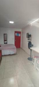 Zimmer mit einem Bett und einem Schreibtisch mit Kamera in der Unterkunft Guest House Renascer K&W in Cabo Frio