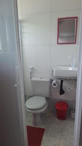ein Badezimmer mit einem weißen WC und einem Waschbecken in der Unterkunft Guest House Renascer K&W in Cabo Frio