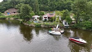 twee boten zijn aangemeerd in een rivier met huizen bij CHALET Orsova in Orşova