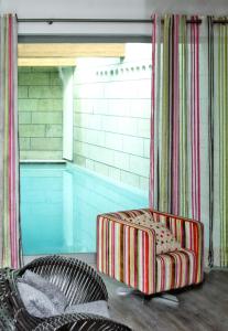 una sedia seduta sul pavimento accanto alla piscina di 4 bedrooms villa with indoor pool jacuzzi and enclosed garden at Santo Tirso a Santo Tirso