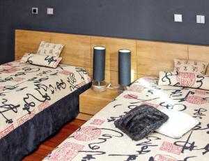 1 dormitorio con 2 camas con almohadas y cabecero en 4 bedrooms villa with indoor pool jacuzzi and enclosed garden at Santo Tirso, en Santo Tirso