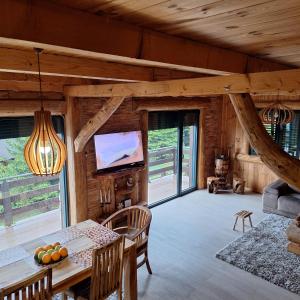 a dining room with a table and a television in a cabin at Vila Tea Durmitor in Žabljak