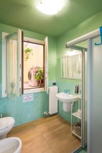 a green bathroom with a sink and a window at Appartamento Happy in Verona