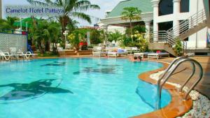a swimming pool with a dolphin in the water at The Camelot Hotel Pattaya in Pattaya South