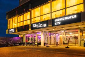 a building with a table in front of it at night at Tulip Inn Ludwigshafen City in Ludwigshafen am Rhein