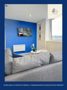 - un salon avec un canapé et un mur bleu dans l'établissement Flat 507 Modern Luxury Living, à Yeadon