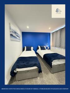 2 camas en un dormitorio con una pared azul en Flat 507 Modern Luxury Living, en Yeadon