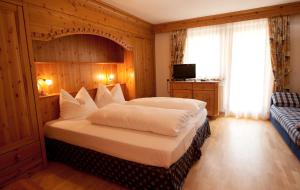 1 dormitorio con 1 cama grande y 1 sofá azul en L'GROF - AL CONTE, en San Martino in Badia
