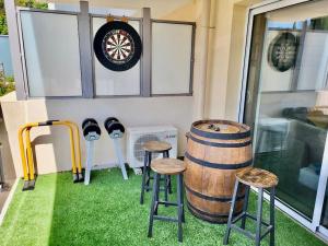 a room with three stools and a barrel at Superbe appartement au calme in La Garde