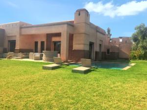 um edifício com piscina em frente a um quintal em 3 bedrooms villa with private pool and enclosed garden at Marrakech em Douar bel Rhanodour