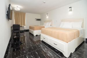 Habitación de hotel con 2 camas y escritorio en Diplomat Inn en Niagara Falls