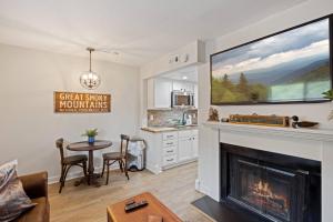 a living room with a fireplace and a kitchen at Beary Convenient is a Newly Renovated King Suite Condo in the heart of Gatlinburg with pools in Gatlinburg