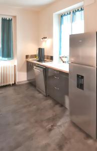 a kitchen with a refrigerator and a sink at Maison de 7 chambres avec jardin clos et wifi a Montsalvy in Montsalvy