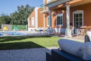 um quintal com uma piscina e uma casa em Quinta das Yuccas em Boliqueime