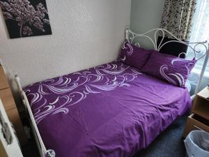 a bedroom with a purple bed with a purple comforter at Glen Allan in Blackpool