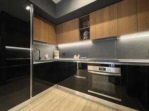 a kitchen with stainless steel appliances and wooden cabinets at Garibaldi Suite 2 Renovated 1BR with Parking, Old Town Olbia in Olbia