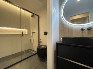 a bathroom with a shower and a toilet and a mirror at Garibaldi Suite 2 Renovated 1BR with Parking, Old Town Olbia in Olbia