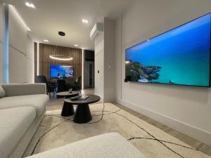 a living room with a large flat screen tv on the wall at Garibaldi Suite 2 Renovated 1BR with Parking, Old Town Olbia in Olbia