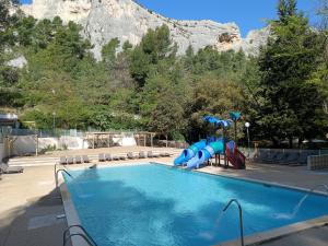 una piscina con tobogán y un parque infantil en Camping de la Vallée Heureuse en Orgon