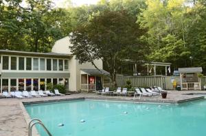 a swimming pool with chairs and a house at Obear Mountain is a Newly Updated Condo in Chalet Village of Gatlinburg! in Gatlinburg