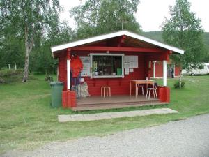 a small red house with a table and chairs at Vetsikon Leirintämökit in Utsjoki
