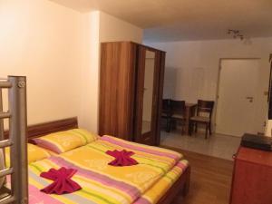 ein Schlafzimmer mit einem Bett mit roten Bögen darauf in der Unterkunft Apartment EM in Harrachov