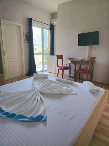 a large white bed in a room with a table at Apartments Vista Mar in Orikum