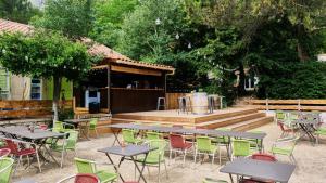 un grupo de mesas y sillas en un patio en Camping de la Vallée Heureuse, en Orgon