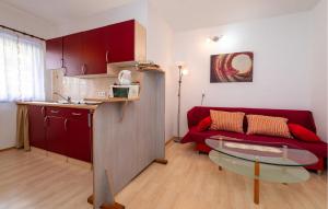 a living room with a red couch and a table at Beach Front Apartment In Rovanjska in Rovanjska