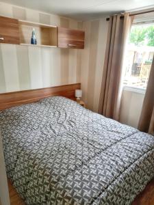 Schlafzimmer mit einem Bett und einem Fenster in der Unterkunft Bungalow de 2 chambres a Valras Plage a 200 m de la plage avec piscine partagee et terrasse in Valras-Plage