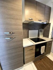 una cucina con mobili in legno e un forno a piano cottura di Le 43 location bord de mer a Marsiglia