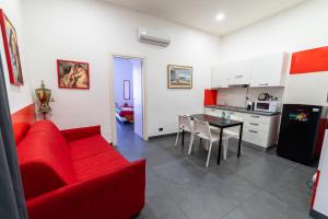 Il comprend un salon avec un canapé rouge et une cuisine. dans l'établissement Arka Apartments, à Naples