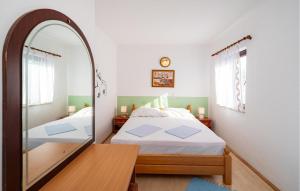 a bedroom with a mirror and a bed at Stunning Apartment In Rovanjska in Rovanjska